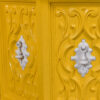 Detail on ornate white pull handles on yellow side tables