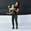 Woman holding large brass unicorn sculpture on wood base