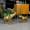 Large scale brass elephants next to a burl Thayer Coggin bar and fern plant
